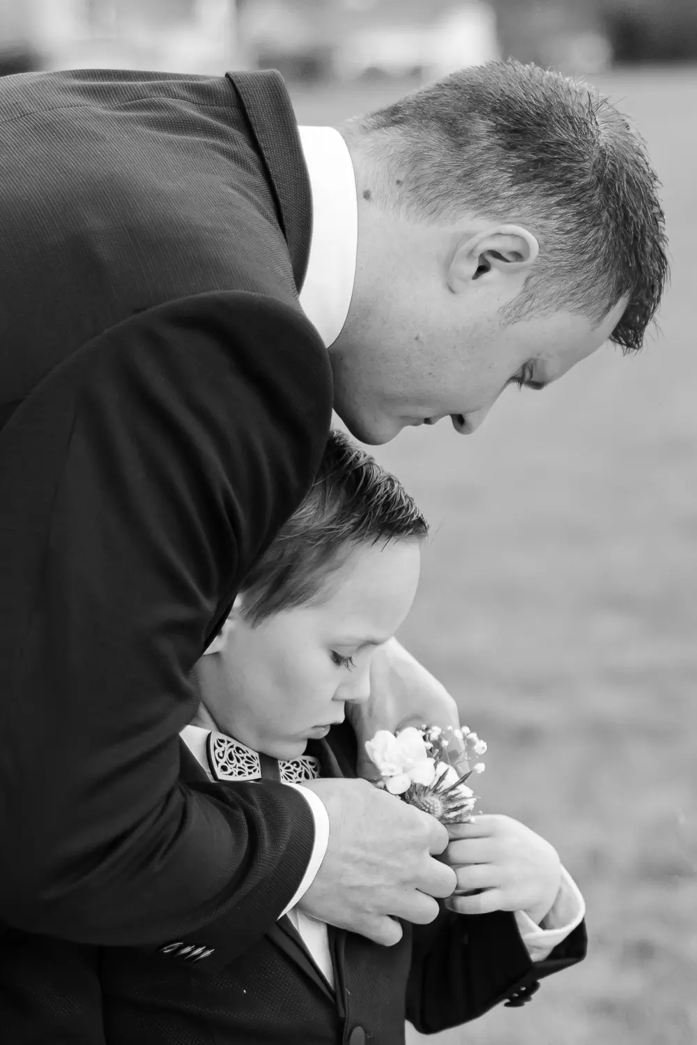 mariage-photographe-isere marié ajustant la boutonnière de l'enfant d'honneur