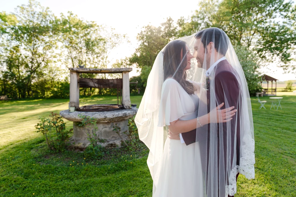 Mariés sous le voile dans le parc de la Ferme du Tremblay dans l’Ain