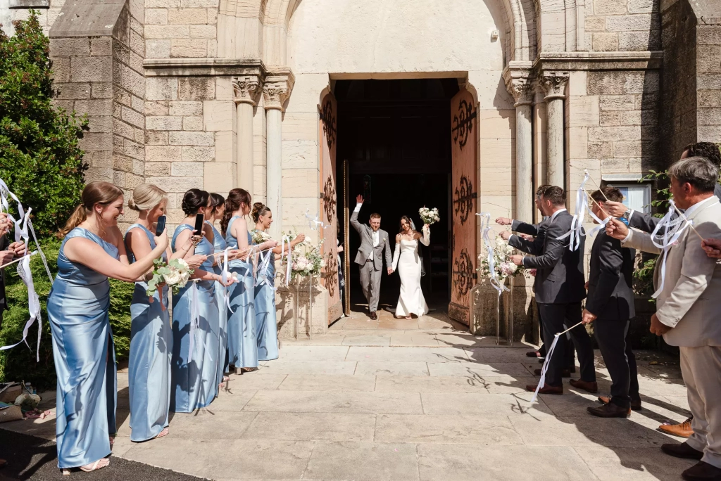 Newlyweds leaving a French church surrounded by their wedding guests
