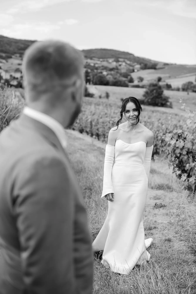 Bride walking through the Beaujolais vineyards towards her husband